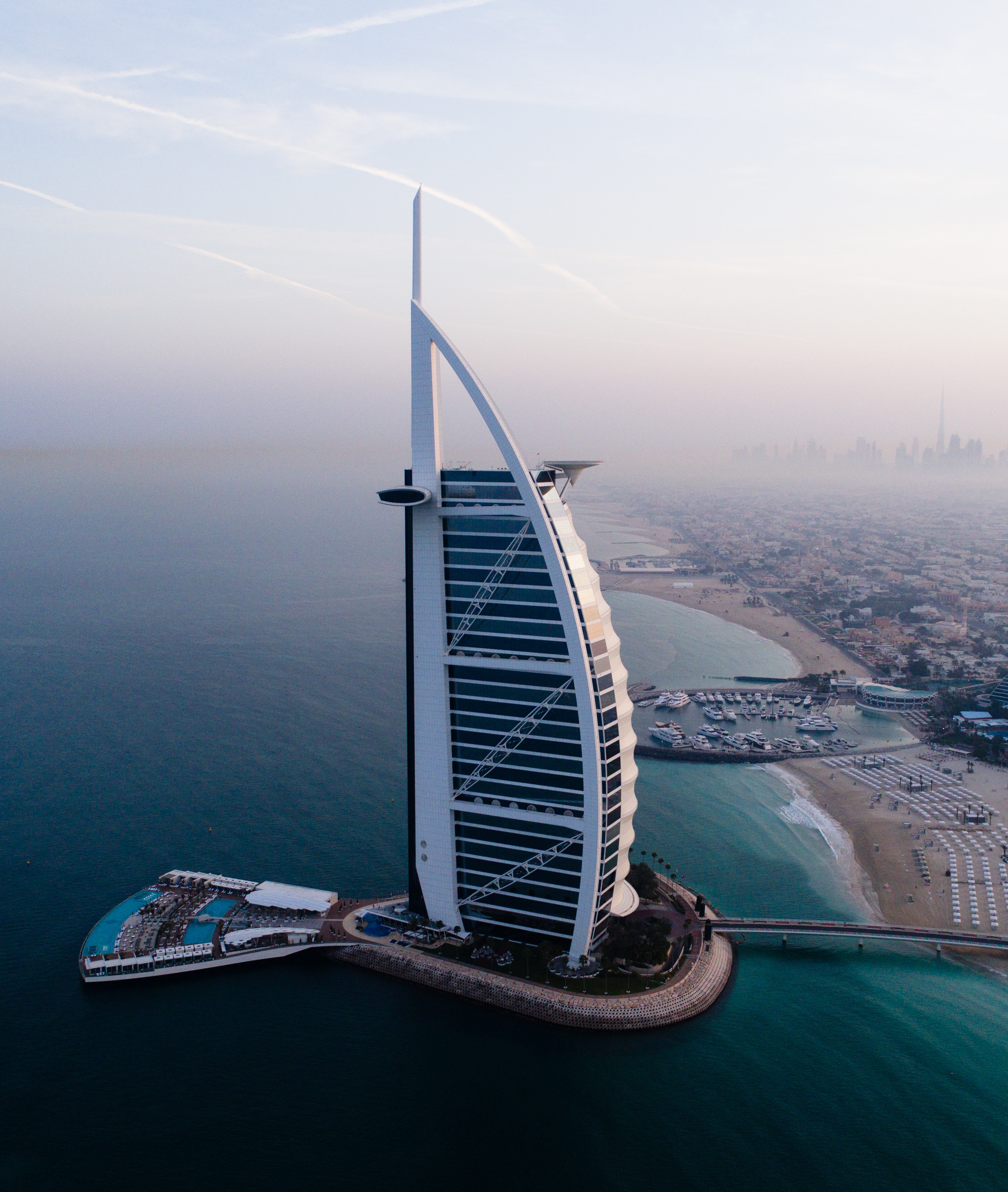 a tall building on a small island with Burj Al Arab in the background