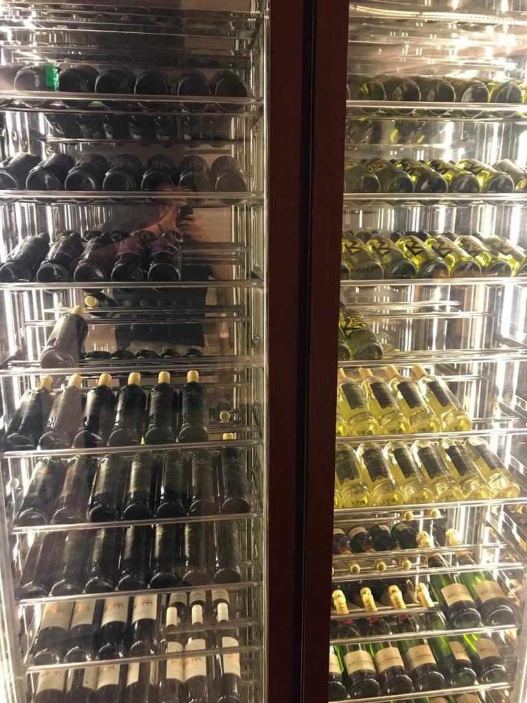 a glass shelves with bottles of wine